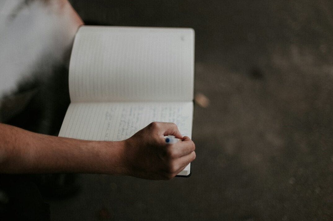 person writing in notebook